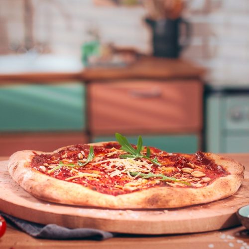 Vegane Pizza mit Rucola und Pinienkernen